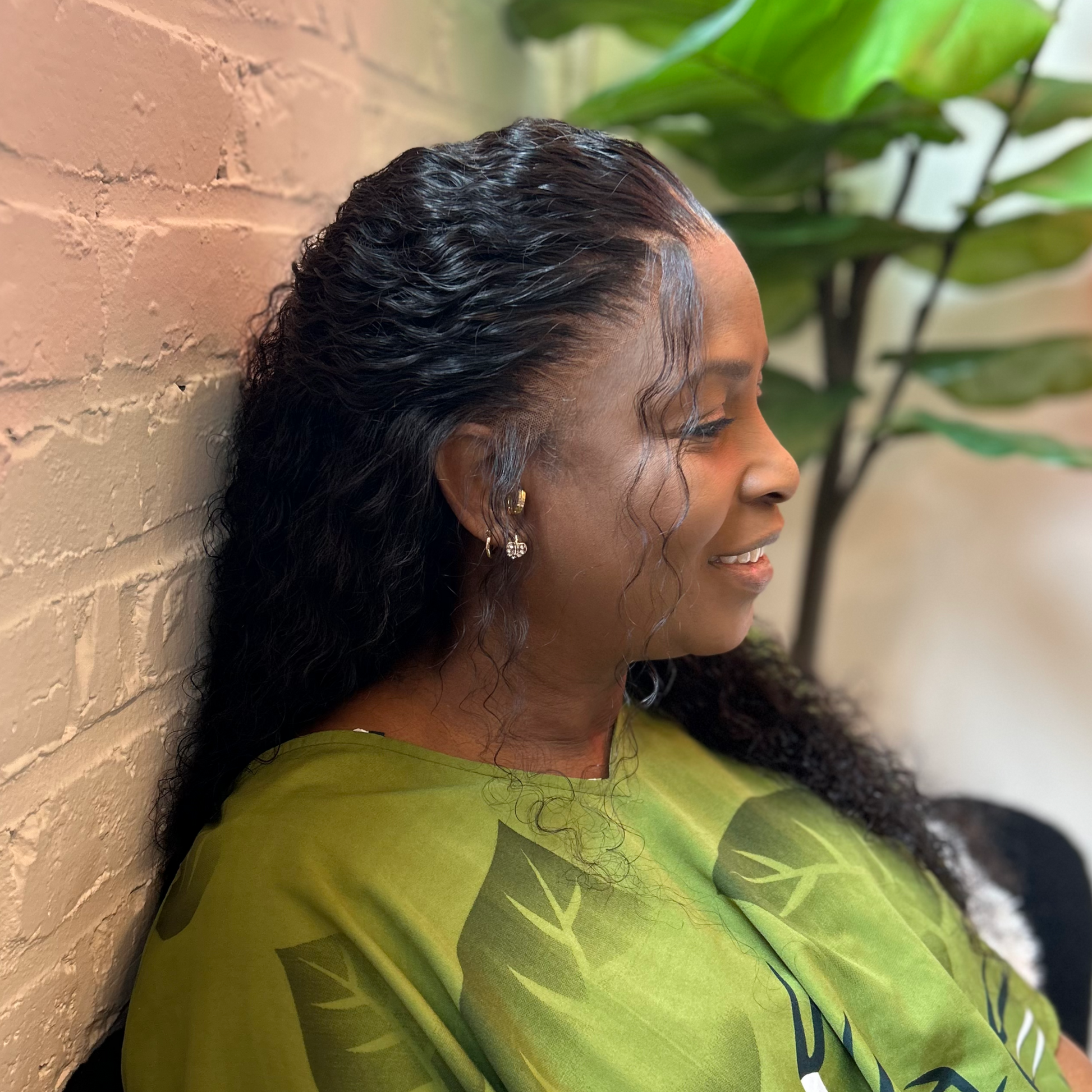 Black woman wearing a glueless HD frontal deep wave unit with a natural hairline
