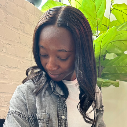 Black woman wearing a glueless middle part HD closure unit with a natural hairline